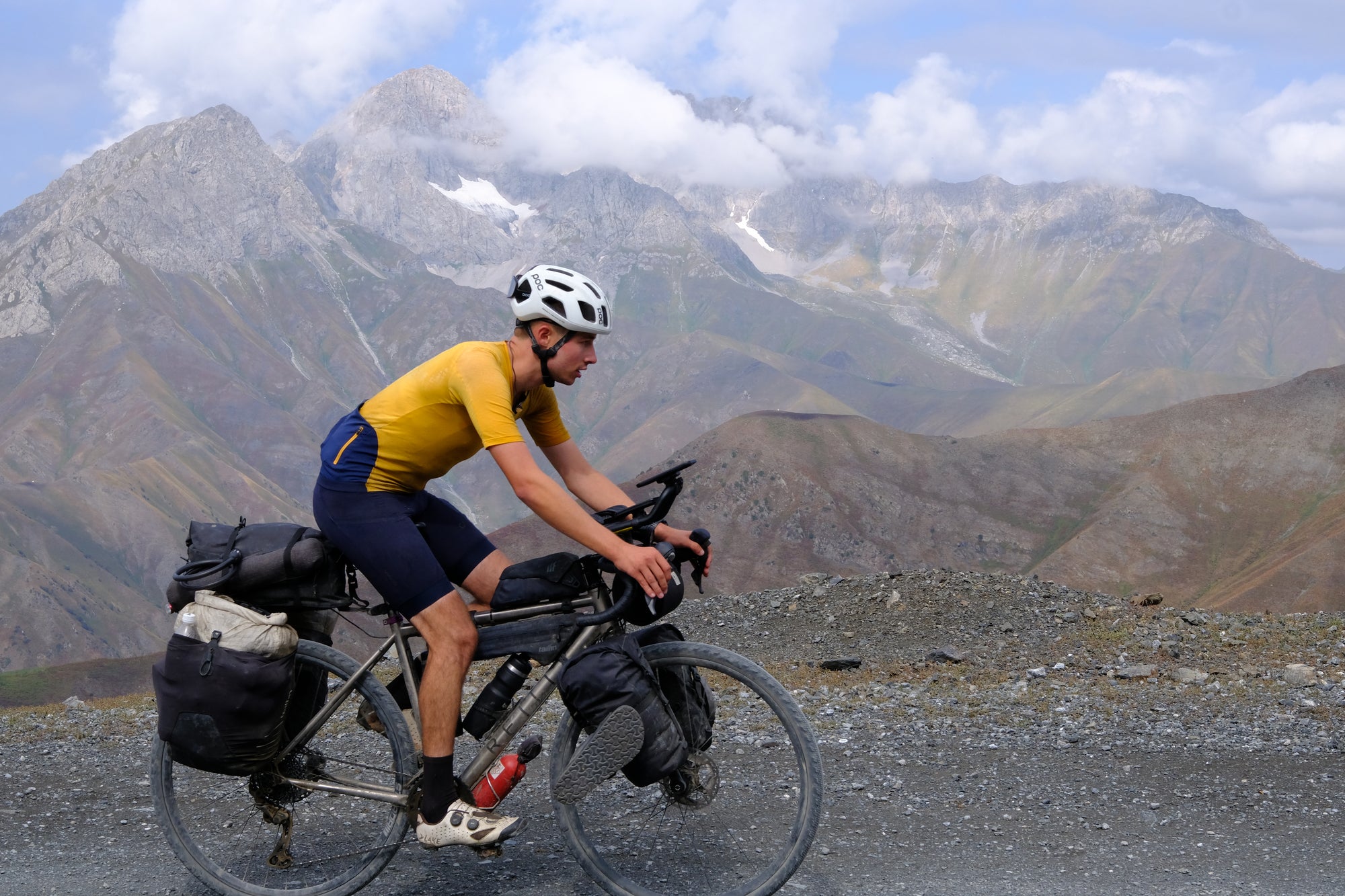 Biker on a mountain road with mountains in the background