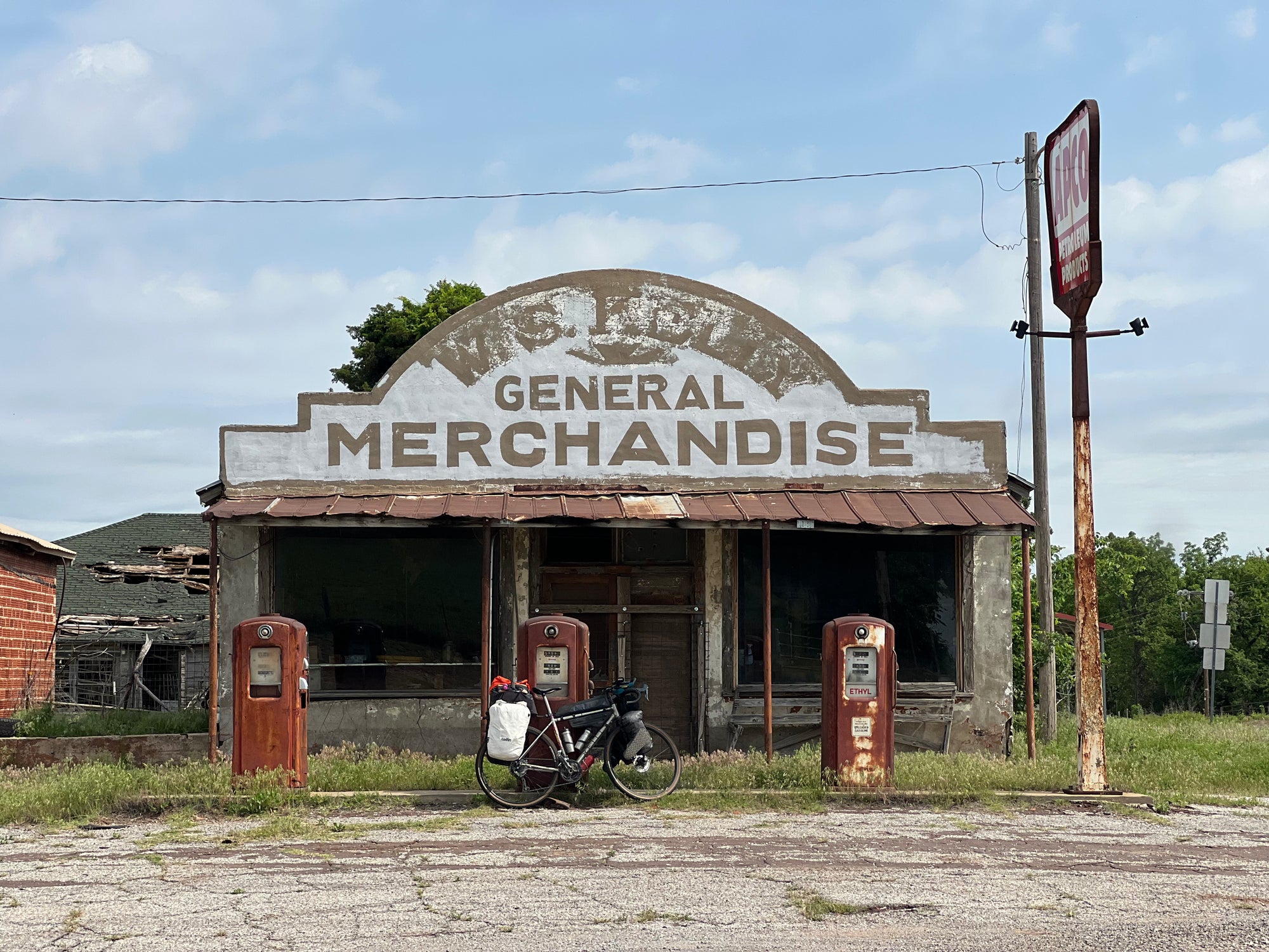 Abandoned general store with faded 'Wells' sign against a blue sky.