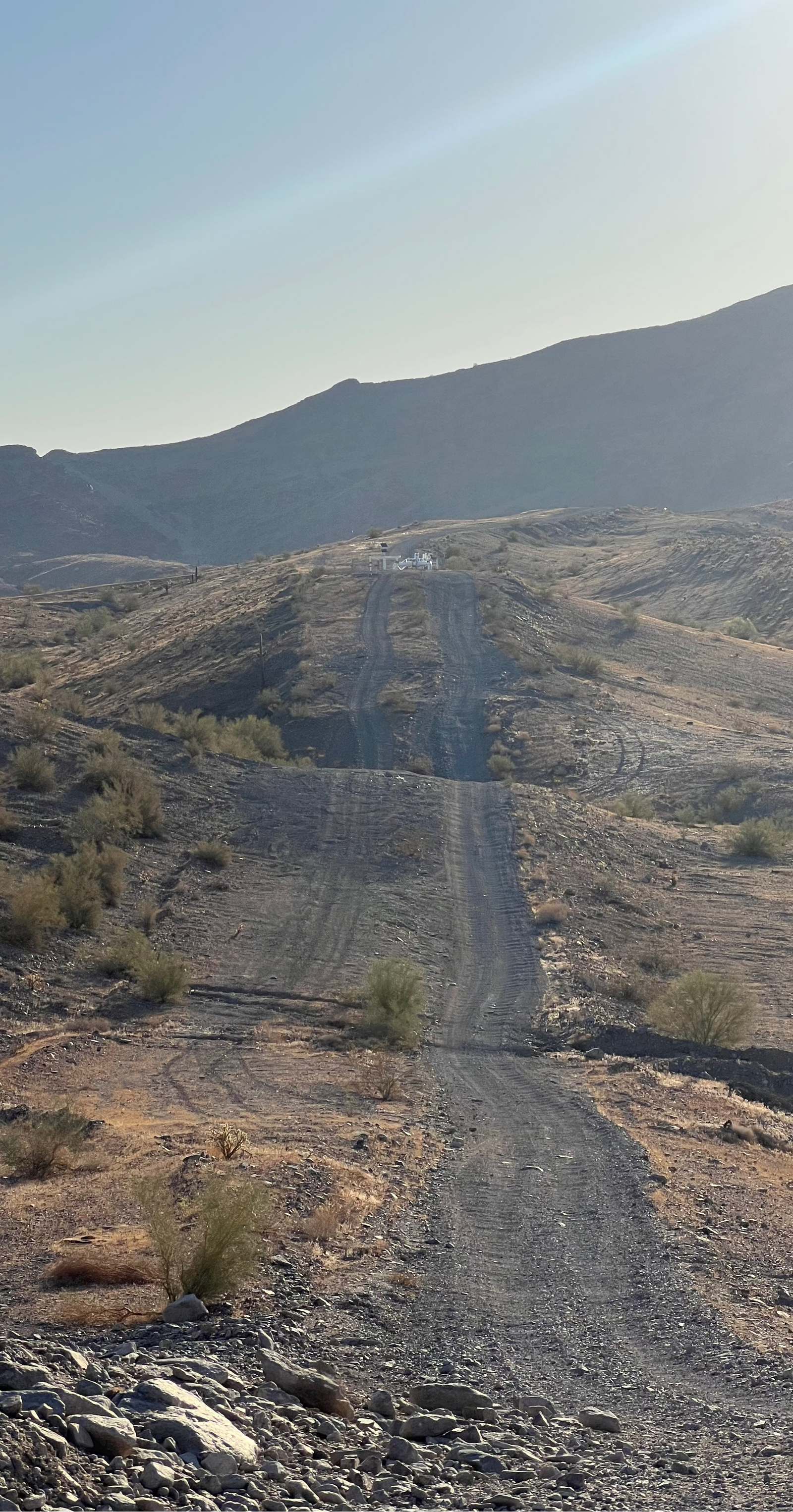 Desert landscape with a dirt road leading into mountains