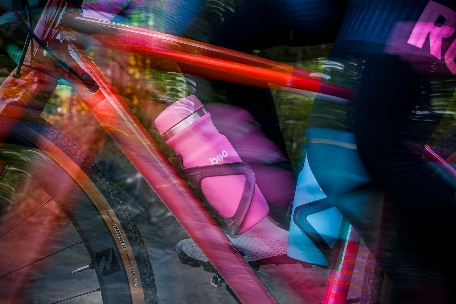 Pink Bivo bottle with black cage attached to a specialized gravel bike frame