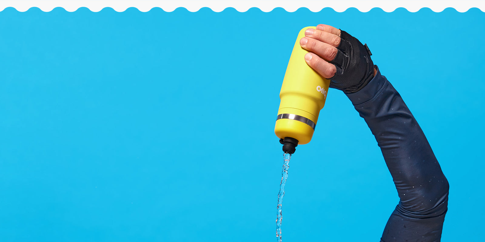 Sun Bivo stainless steel bottle being held by a hand in a bike glove against a blue background.