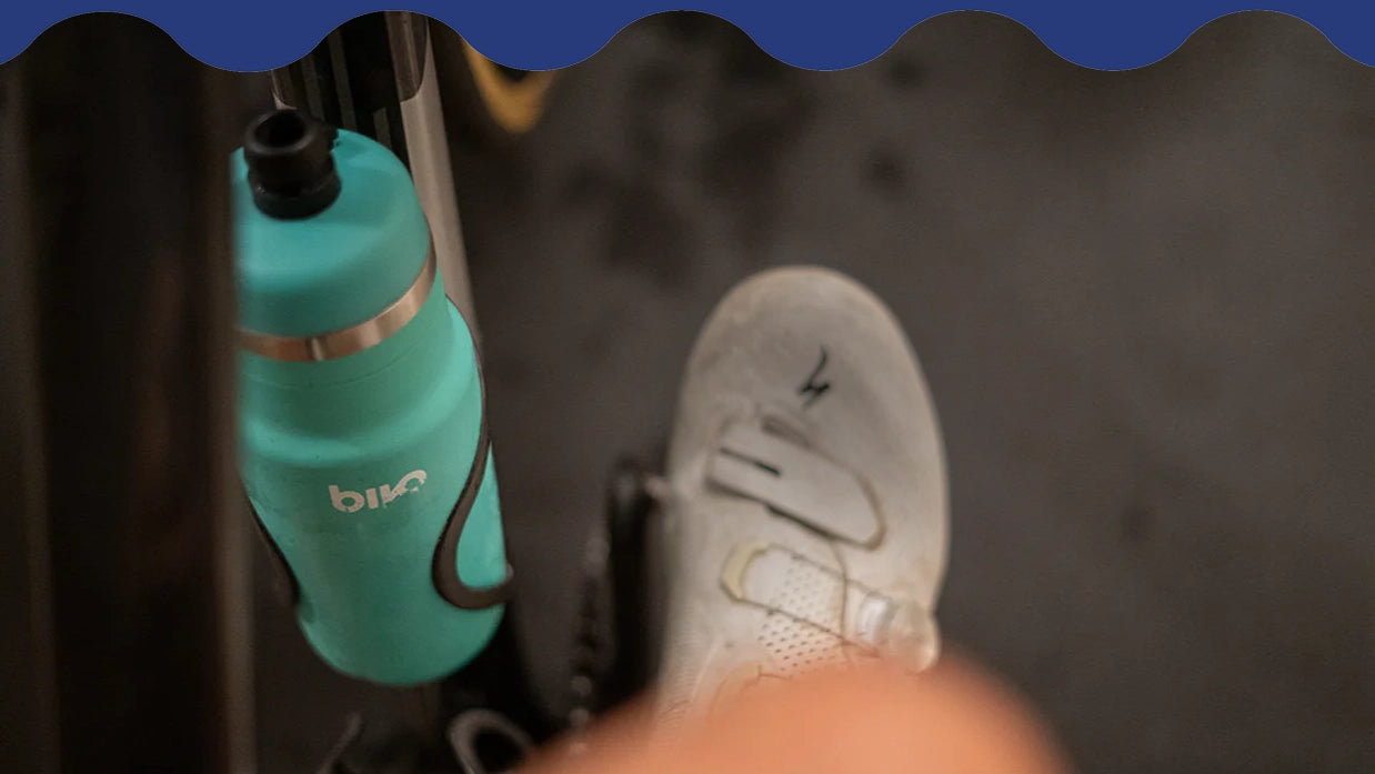 Turquoise Bivo water bottle with Bivo branding on an indoor trainer bike.
