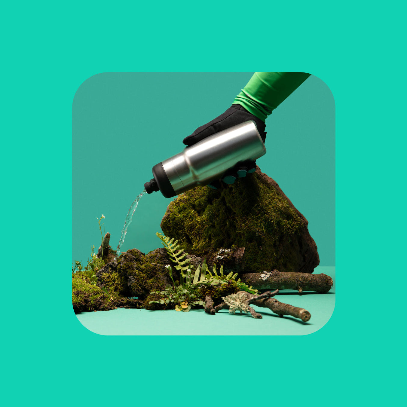 Hand with a Raw water bottle watering plants on a green background.