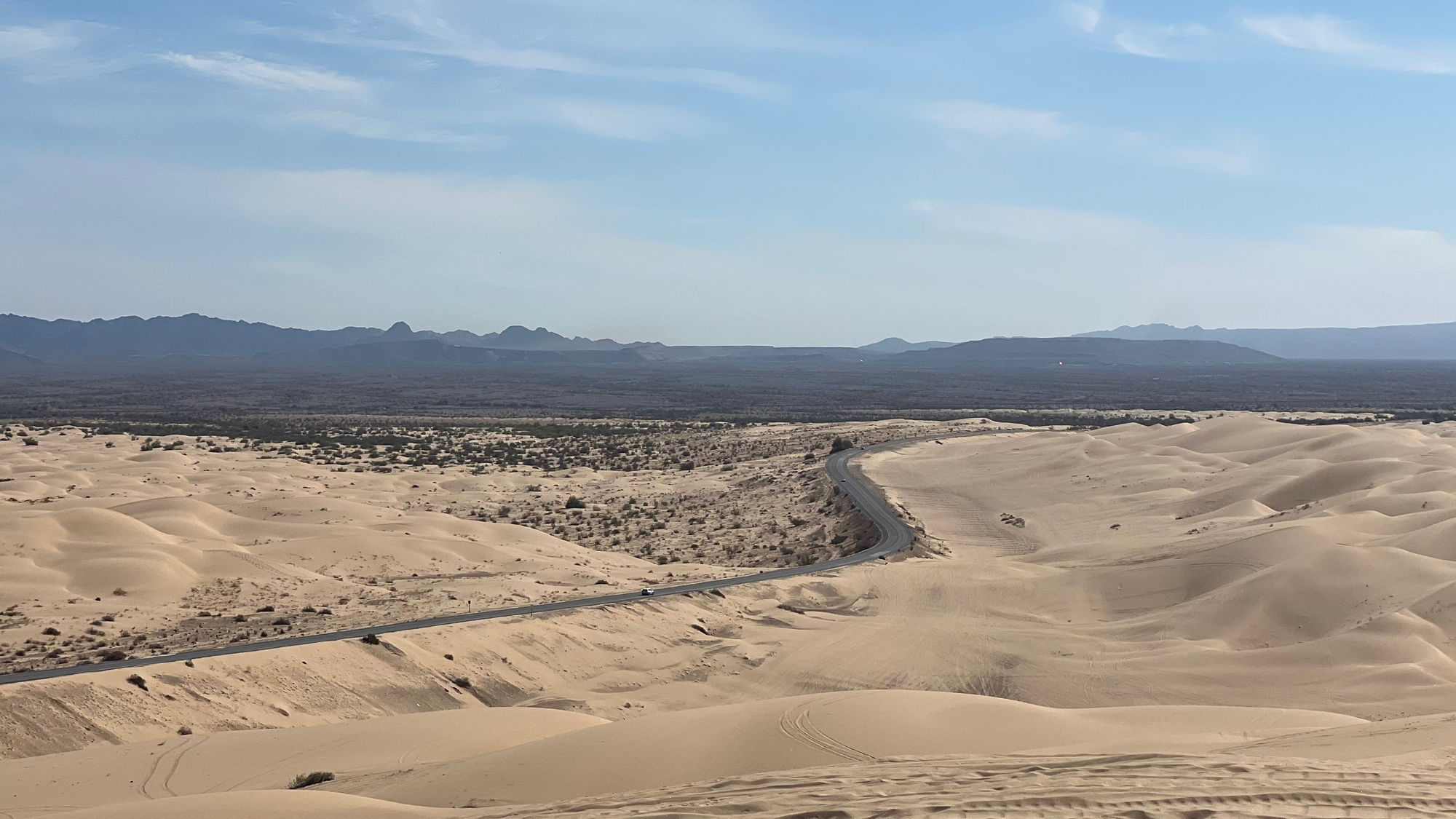 Desert landscape with sand dunes and mountains in the distance